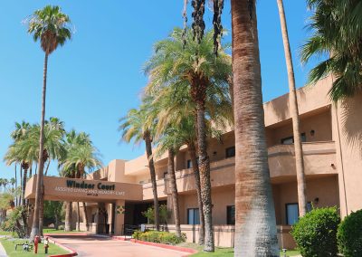 The side view of the front entrance of Palm Court Assisted Living