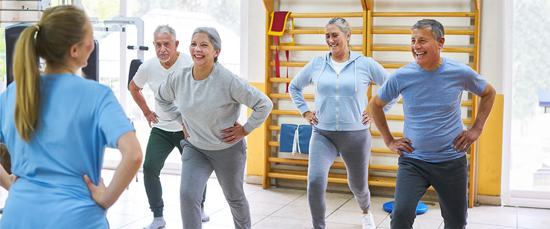 Group of seniors being led in exercises by an instructor.